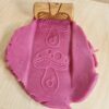 Houten sensorische roller met rose klei van het merk Kiddi met ingegraveerd paddenstoelenpatroon – ideaal voor sensorisch spel met klei of speelzand.