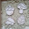Eikel, egel, blad, paddestoel stempel zand houten mini vulvormen liggend op zand, te gebruiken met magisch zand en o.a. speelrijst voor sensorisch spel in thema herfst