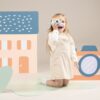 houten-educatief-camera-voor-kinderen-woet-rollenspel Kind speelt met Woet houten camera rollenspel speelgoed