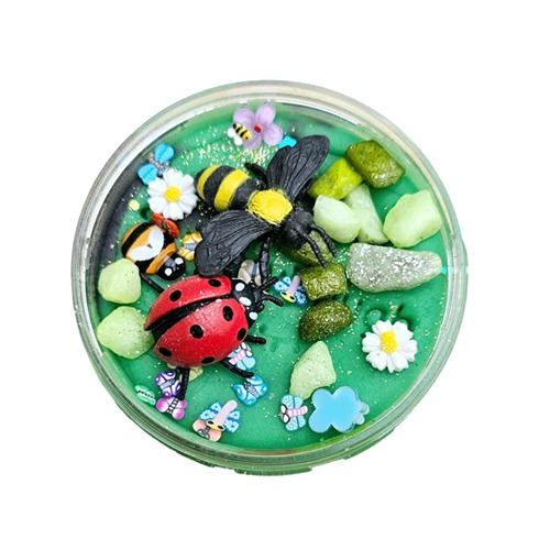 Sensoryfun-sensorische-speelklei-insecten Groene sensorische klei, versierd met een plastic lieveheersbeestje, bij, kleurrijke steentjes, bloemetjes en kleine vlinders – vrolijke lentetuin in miniatuurformaat.